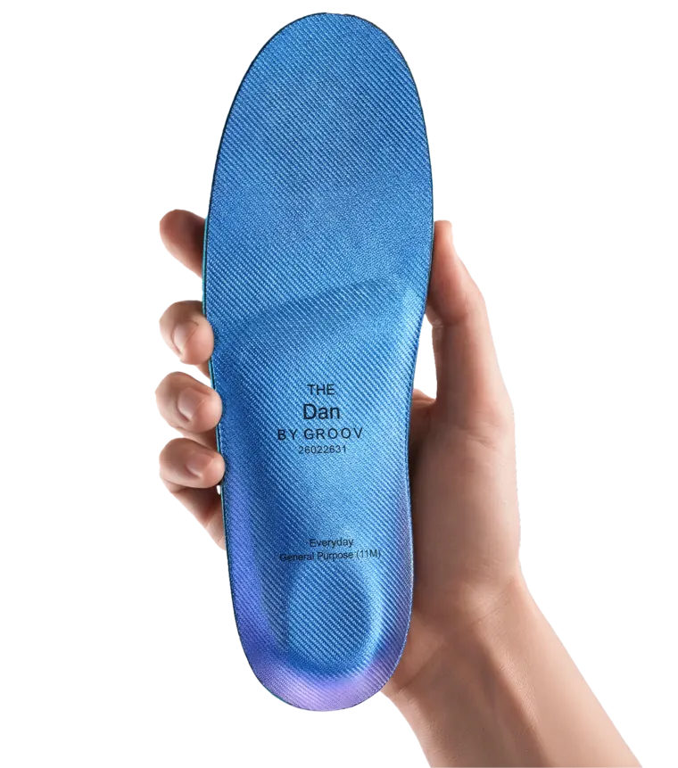 A hand holding The Everyday custom insole.